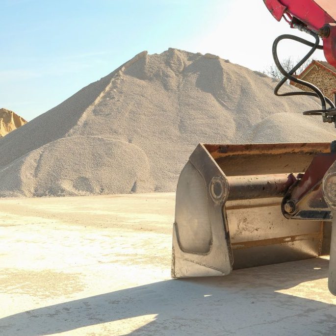 Quarry on a site with piles of sand and gravel for construction.